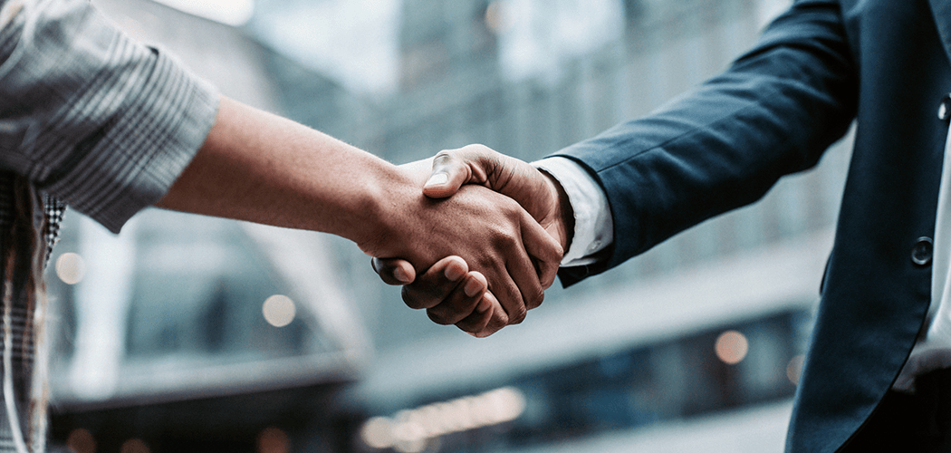 Two people shaking hands with a blurred background